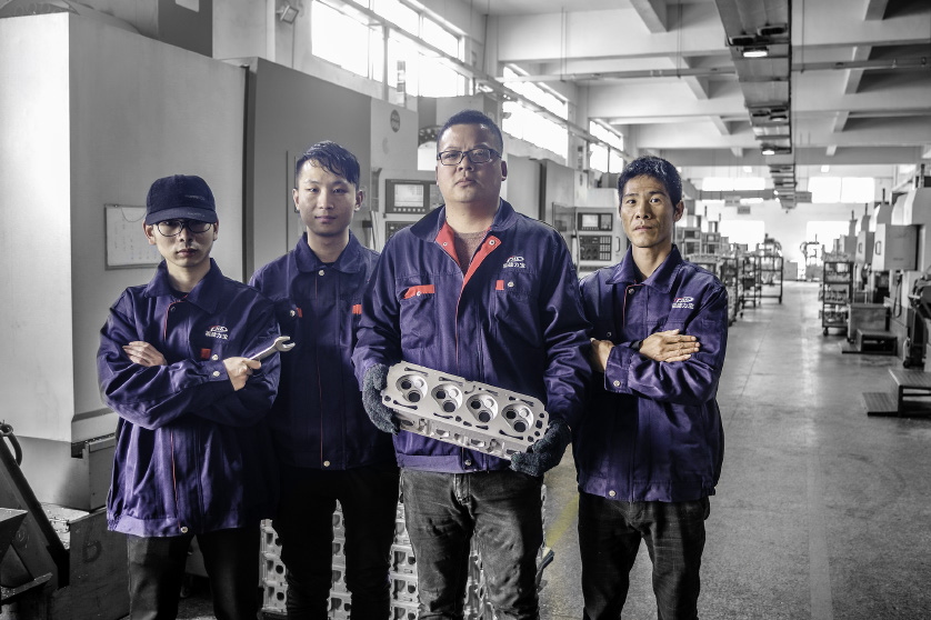 Factory quality team holding a cylinder head